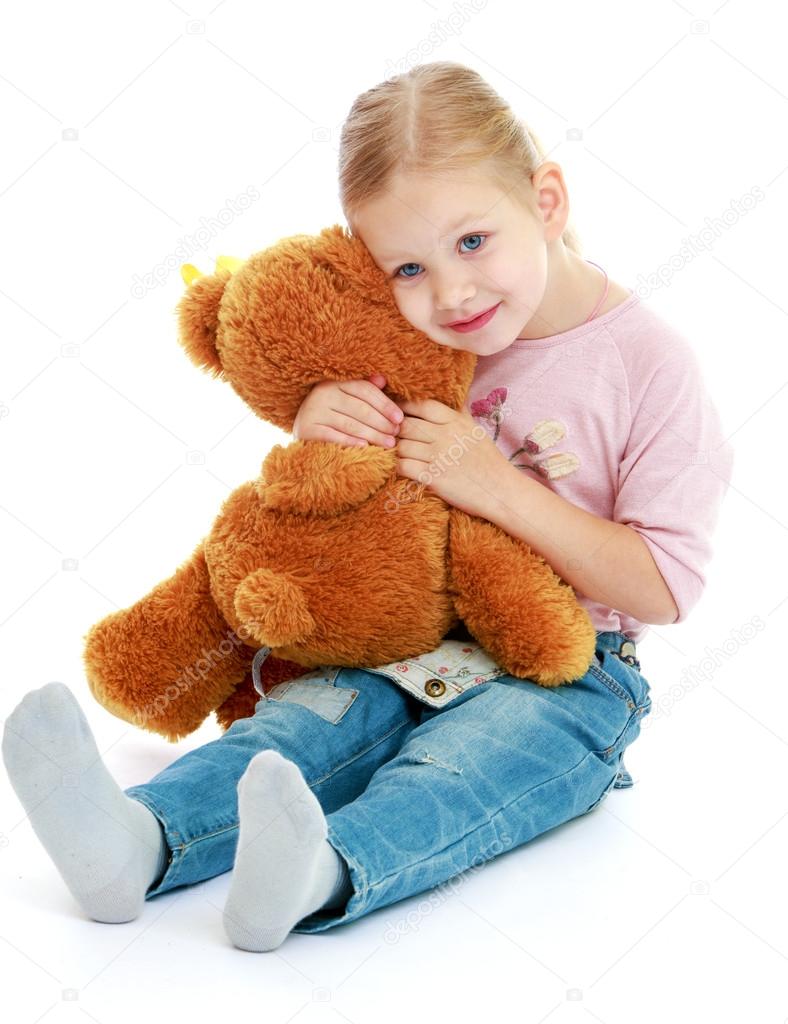 Little girl hugging a teddy bear. Stock Photo by ©lotosfoto1 55130267