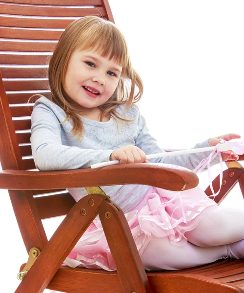 Neşeli küçük kız büyük bir tahta sandalyede dinleniyor. — Stok fotoğraf
