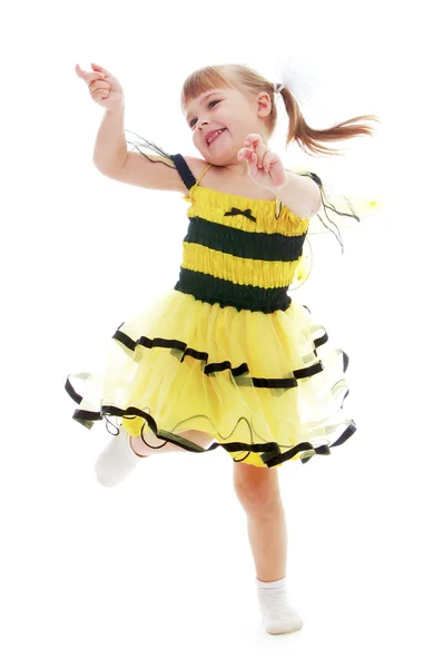 Niña alegre en un vestido amarillo saltando y divirtiéndose . —  Fotos de Stock