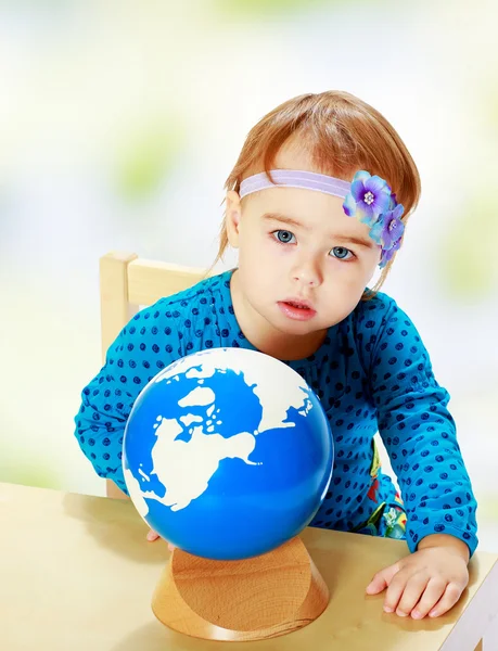Little girl examines the globe. — Stock Photo, Image