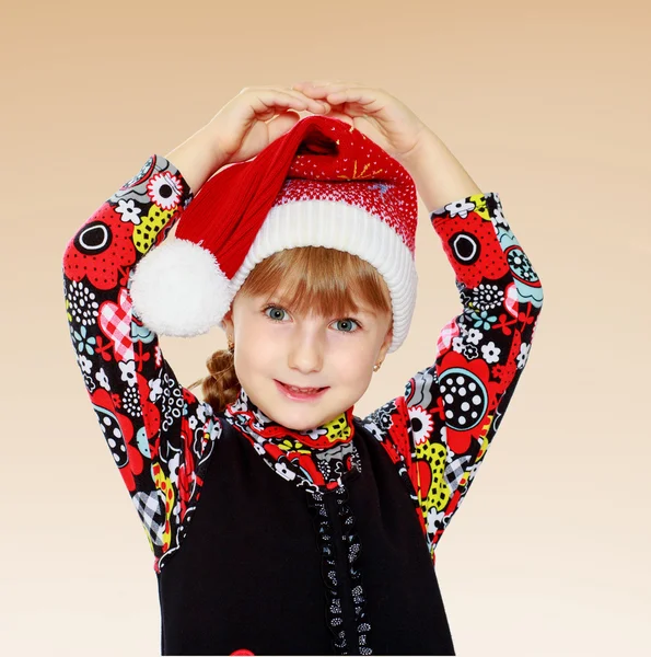 Little girl in santa claus hat ale a lesson. — Stock Photo, Image