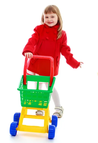 Allegro bambina in rosso cappotto utilità prodotti . — Foto Stock