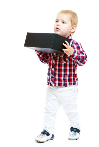 Little boy holding a big black box. — Stock Photo, Image