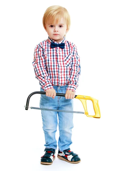 Pequeño niño sosteniendo una sierra . — Foto de Stock