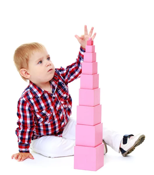 Liten pojke bygger en pyramid i Montessori skolan. — Stockfoto