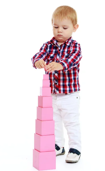 Little boy builds a pyramid in the Montessori school. — Stock Photo, Image