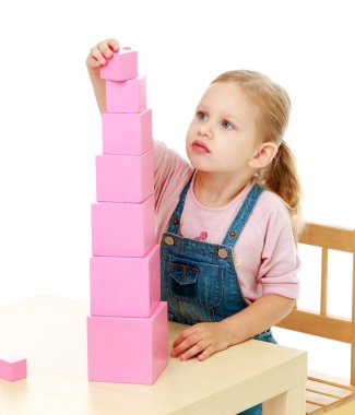 Küçük kız pembe piramit toplar.