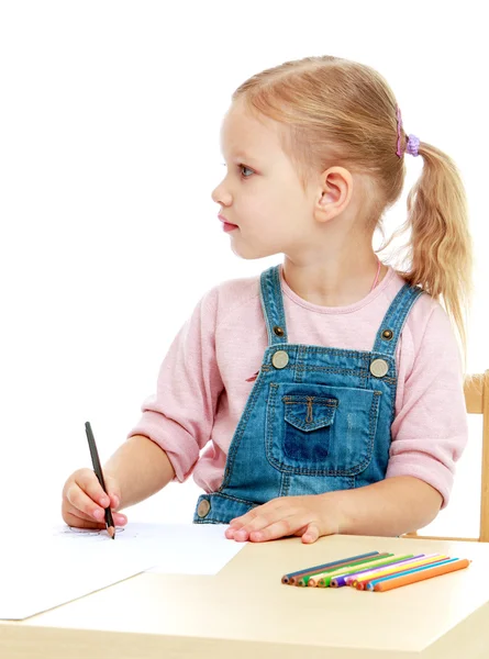 Meisje trekt potloden zitten aan de tafel. — Stockfoto