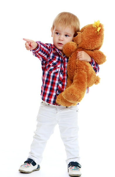 Маленький мальчик обнимает плюшевого мишку
.