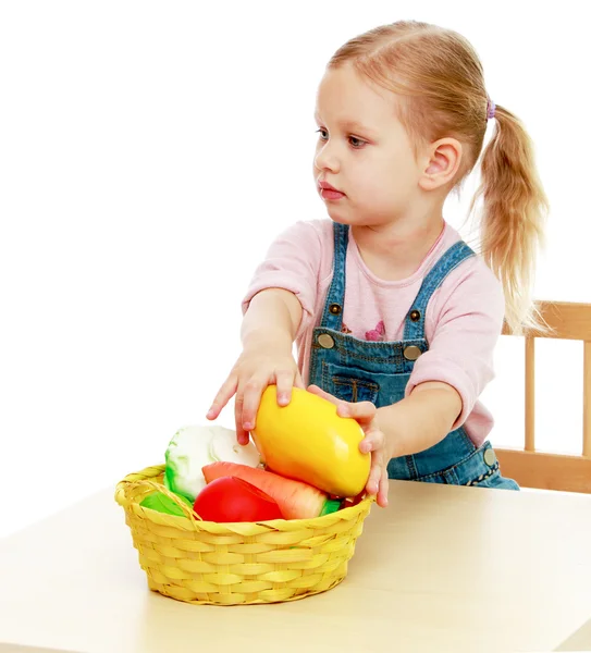 Kleines Mädchen liegt zerlegt in Obstkorb. — Stockfoto