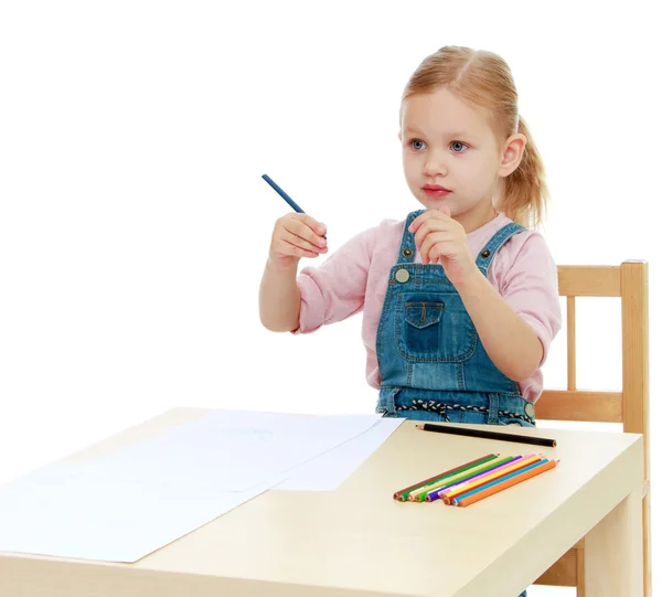 Lilla flickan drar pennor sitter vid bordet. — Stockfoto