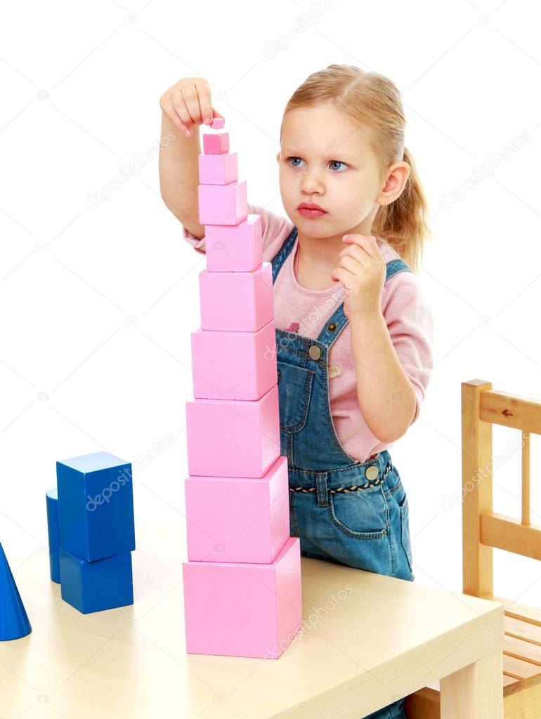 Little girl collects the pink pyramid.