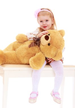 Sevimli küçük kız bir oyuncak ayı sarılma.