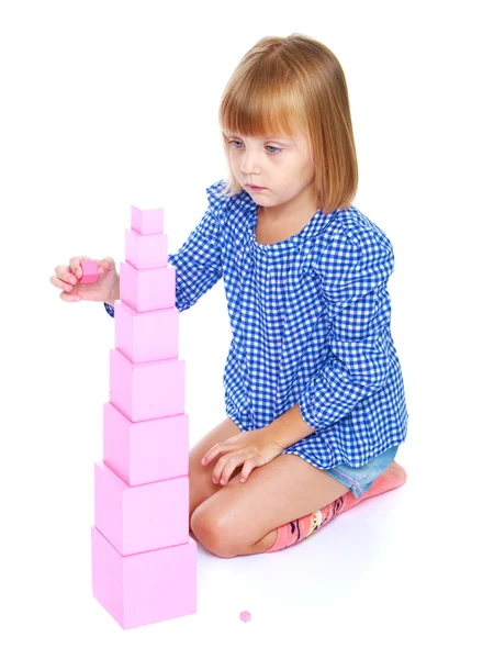 Küçük kızı kucağında oturan Montessor yüksek pembe kule inşa — Stok fotoğraf