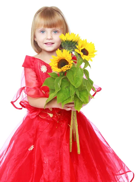 Malá princezna drží zářivě žluté květy. — Stock fotografie