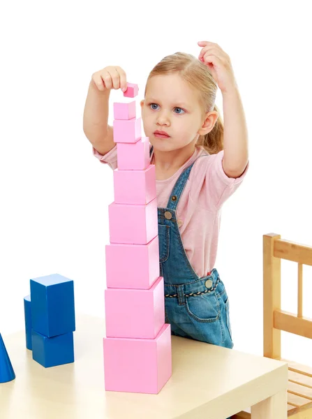Kleines Mädchen sammelt die rosa Pyramide. — Stockfoto
