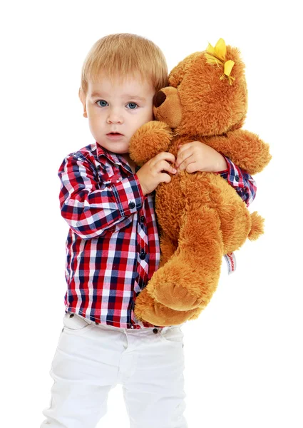 Pequeño niño abrazando a un oso de peluche . — Foto de Stock