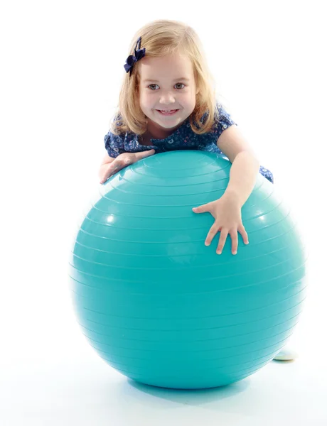 Kleines Mädchen reitet großen Sportball. — Stockfoto