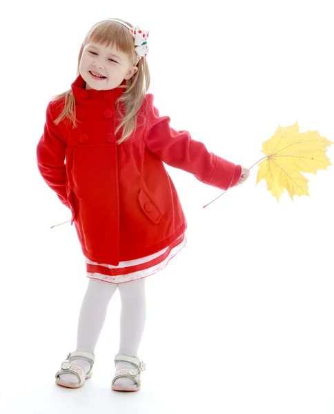 Little girl in autumn coat holding a maple leaf. — Stock Photo, Image