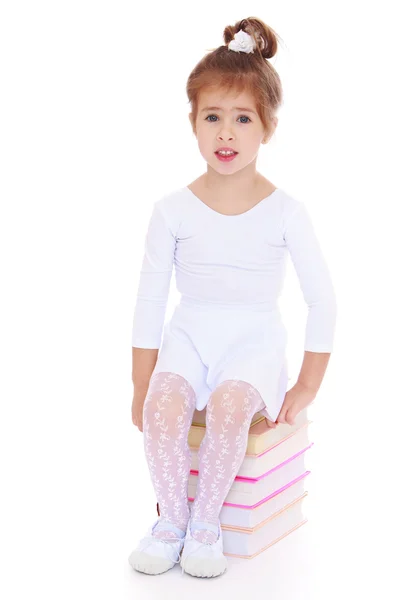 Niña en vestido deportivo sentado en los libros —  Fotos de Stock