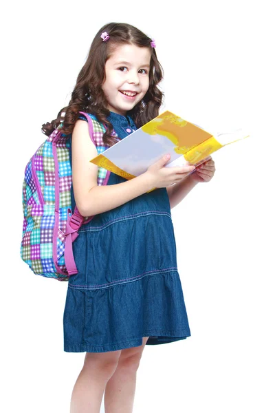 バックパックの本を読んで幸せな小さな女子高生. — ストック写真