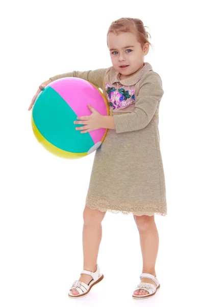 Kleines Mädchen mit großer aufblasbarer Kugel. — Stockfoto