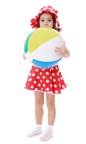 Mała dziewczynka przytulił jej wielki pasiasty piłka plażowa. — Zdjęcie stockowe