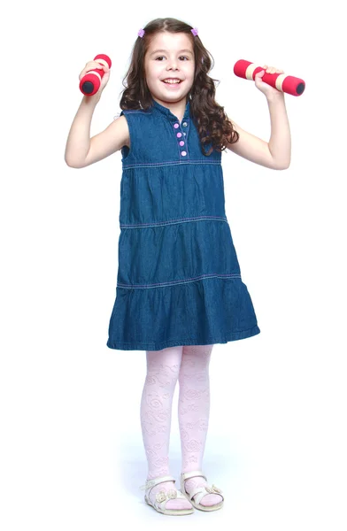 Little girl raises dumbbell over your head. — Stock Photo, Image