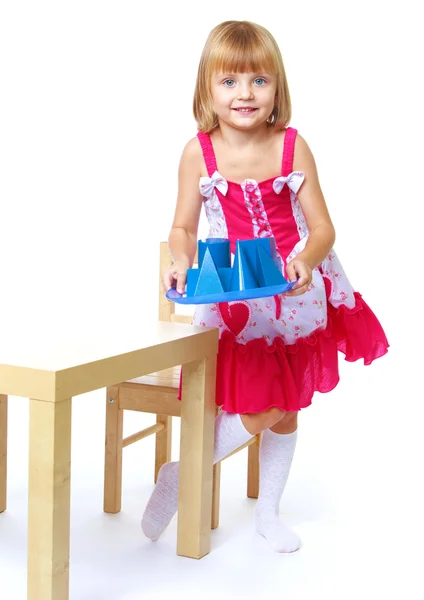 Little girl carrying a tray with cubes. — Stock Photo, Image