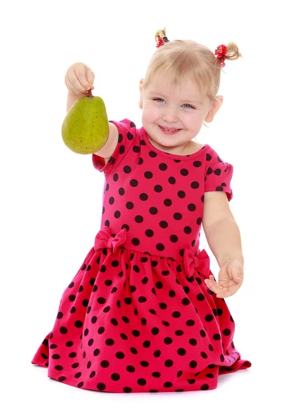 Retrato de una pequeña rubia con pera en la mano . — Foto de Stock