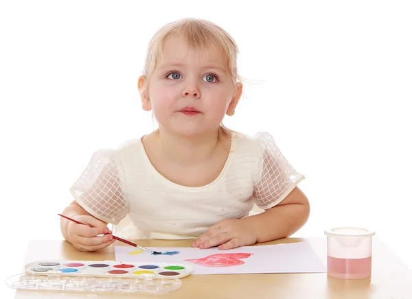 Fechar-se de uma menina inteligente desenha tinta sentada à mesa . — Fotografia de Stock