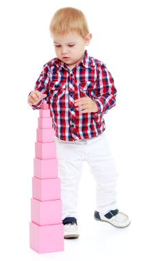 çok küçük çocuk kırmızı piramit Montessori classroo toplar.
