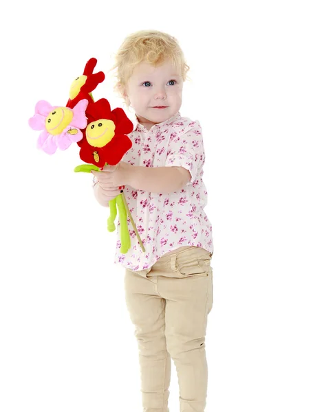 Zeer charmant klein meisje met een boeket van bloemen. — Stockfoto