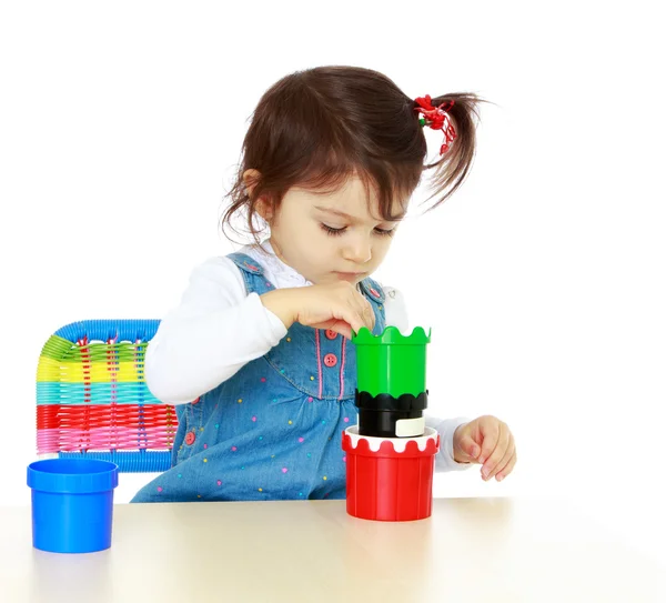 Närbild lilla flicka spela medan du sitter vid bordet. — Stockfoto