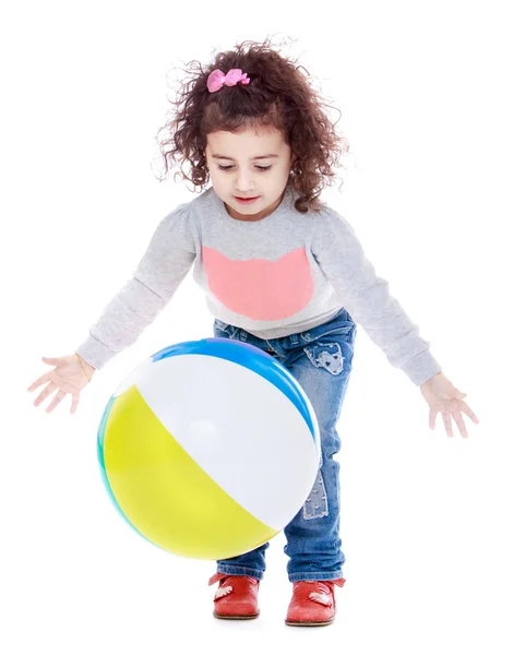 Fröhliches kleines Mädchen, das mit einem Ball spielt. — Stockfoto