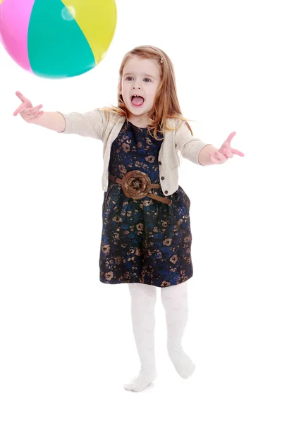Glückliches kleines Mädchen wirft einen hohen Ball. — Stockfoto