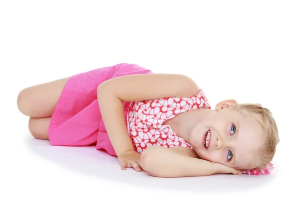 Encantadora niña tendida en el suelo y sonriendo . — Foto de Stock