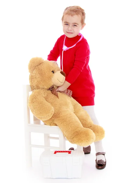 Funny little girl playing in the hospital listening to teddy bea — Stock Photo, Image