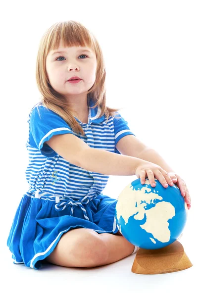 Thoughtful little girl spinning globe. — Stock Photo, Image