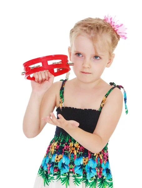 Cute little girl knocks on the tambourine. — Stock Photo, Image