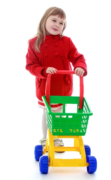 Elegant little girl rolls the cart. — Stock Photo, Image