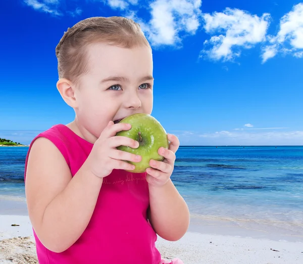 Drôle petite fille mordre une pomme tandis que — Photo
