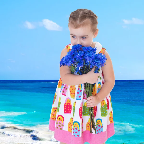 Elegante bambina che profuma un mazzo di fiori in piedi su th — Foto Stock
