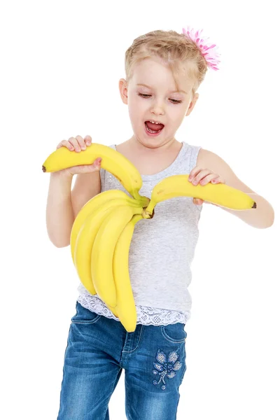 Gelukkig vreugdevolle meisje houdt van een bos van bananen. — Stockfoto