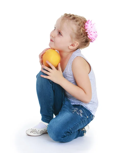 Ładny wesoły dziewczynka trzyma pomarańczowy. — Zdjęcie stockowe