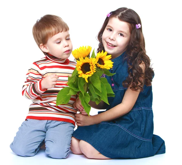 Bruder und Schwester schnüffeln Strauß Sonnenblumen. — Stockfoto