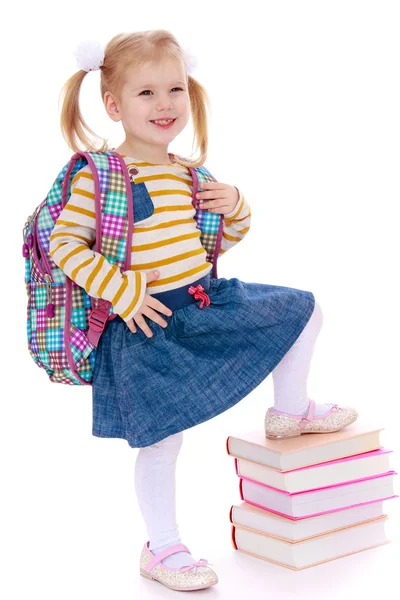 Caucasian beautiful little schoolgirl holding his foot on a stac — Stock Photo, Image