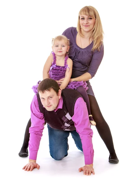 Cheerful family mother and daughter are riding on daddy. — Stock Photo, Image