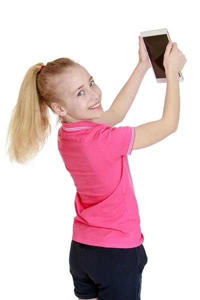 Blond girl sees the tablet holding it at arms length — Stock Photo, Image