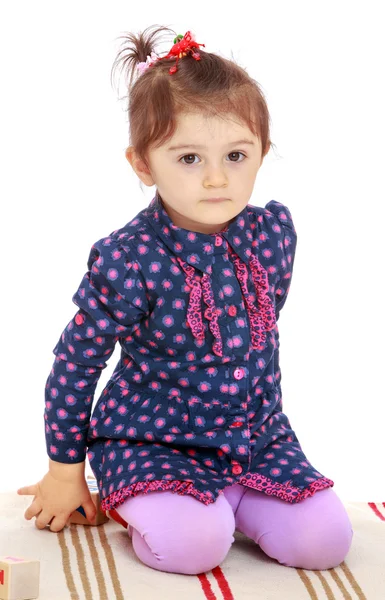 Bambina molto seria seduta su un tappeto — Foto Stock